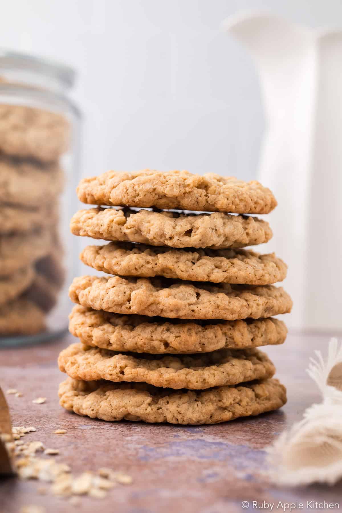 Stack of unglazed, golden brown maple oatmeal cookies with textured edges.