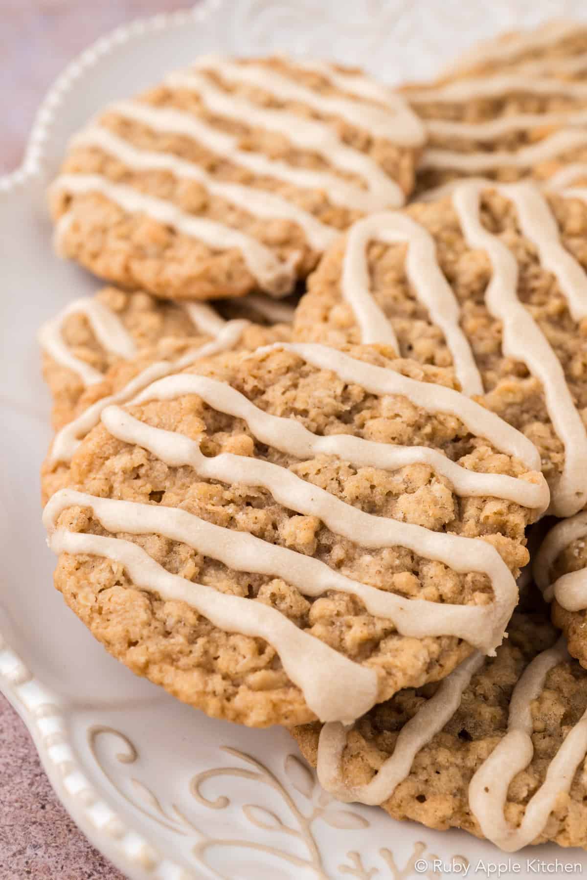 Platter of maple oatmeal cookies with maple glaze drizzled in zigzags across the tops.